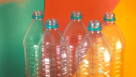 A pack of 5 empty and recyclable water bottles, with no caps, on a colored vi Stock Photos