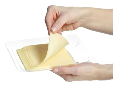 A pack of cheese slices in hands Stock Photos