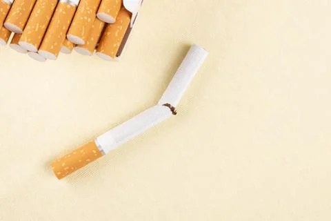 A pack of cigarettes and a broken cigarette, nicotine addiction Stock Photos