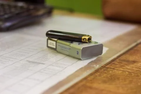 A pack of cigarettes and a lighter on the table Stock Photos