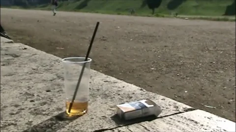 Pack of cigarettes and plastic cup left on the wall Stock Footage 118890539