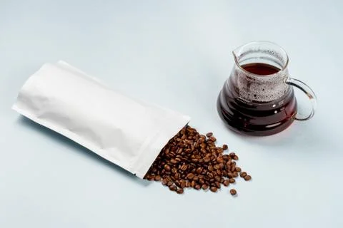 Pack with coffee beans and serving kettle with hoy black coffee Foto stock