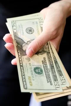 A pack of dollars in hands close-up. To count money. twenty dollar bills. Pay Stock Photos