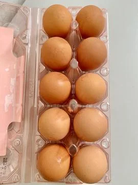A pack of egg in a plastic box container on the table close up Stock Photos