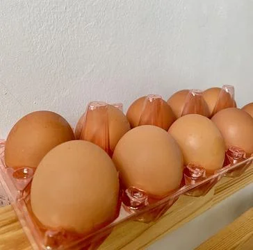 A pack egg in a plastic box container on the table close up Stock Photos
