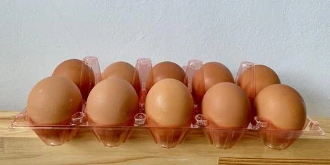 A pack egg in a plastic box container on the table Stock Photos