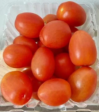 A pack of fresh cherry tomato in a plastic box Close up Stock Photos