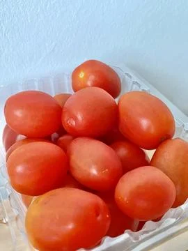 A pack of fresh cherry tomato in a plastic box Close up Stock Photos