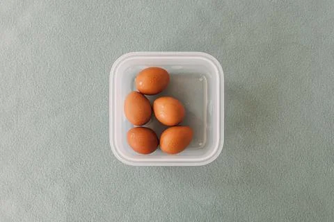 Pack of fresh eggs in plastic box on grey table cover. Stock-Fotos
