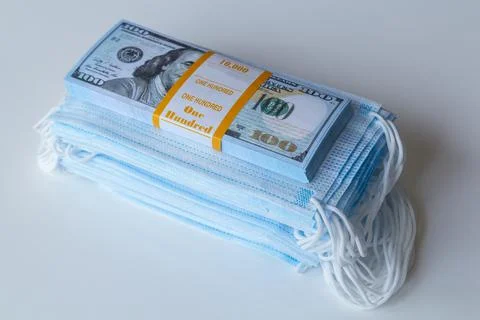 A pack of medical masks and a stack of 100 dollars bills as a symbol of highe Stock-Fotos