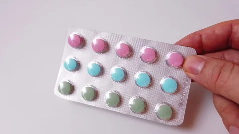 Pack of multi-colored pills with vitamins in hand Stock Footage 128304865