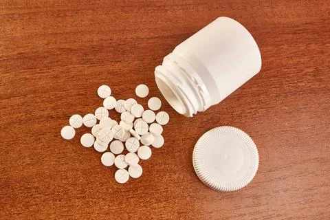 A pack of pills is scattered on the table. Overdose. Stock Photos