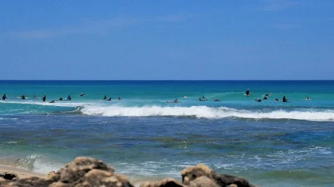 Pack of surfers catching waves low angle summertime Stock Footage 121197883
