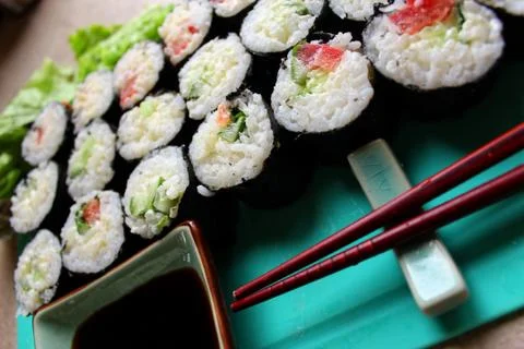 A pack of sushi rolls served with sticks and soy sauce Stock Photos
