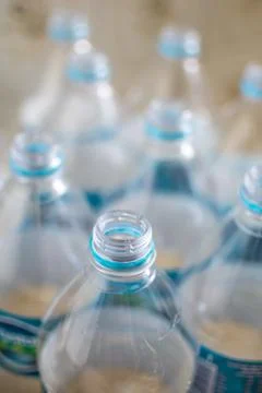 Pack of transparent empty pet plastic water botles with blue label, no cap an Stock Photos