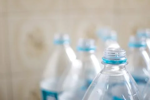 Pack of transparent empty pet plastic water botles with blue label, no cap an Stock Photos