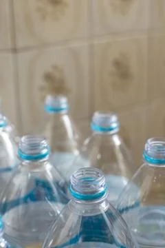 Pack of transparent empty pet plastic water botles with blue label, no cap an Stock Photos