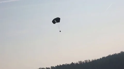 Package being parachuted onto an open field Stock Footage 110885325