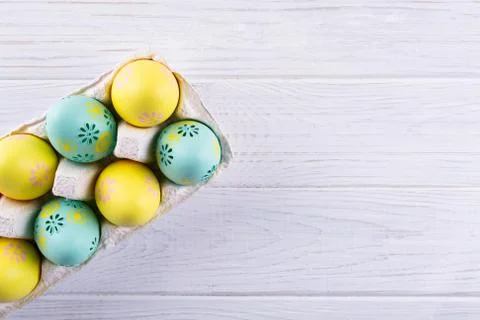 Package box with painted easter eggs. Easter holiday background. Top view. Stock Photos