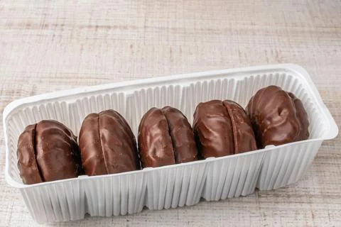 A package of chocolate marshmallows close-up lying on a wooden table. The c.. Stock Photos