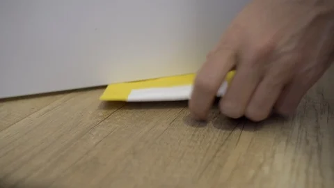 Package delivery - postal envelope slipped under a door and taken by a hand Stock Footage 126042330