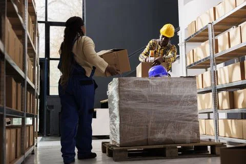 Package handler bringing parcels to warehouse worker for packing Stockfoto's
