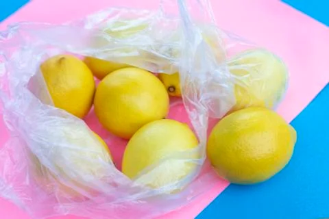 Package with lemons on a pink background Foto stock