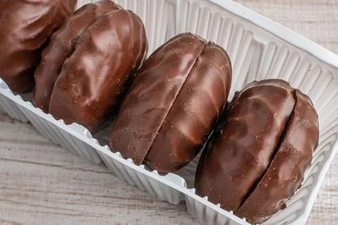 A package of marshmallows in chocolate glaze close-up lying on a wooden table Stock Photos
