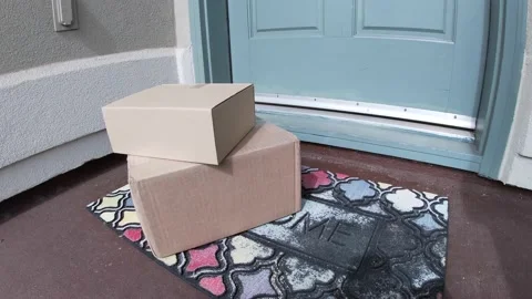 Package on mat outside door which opens and man picks up Stock Footage 120812434
