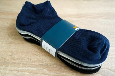 Package of multi-colored men's socks short,woven socks packaged,on wooden floor Stock Photos