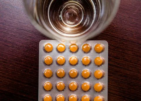 A package of orange tablets is placed on a brown background 写真素材