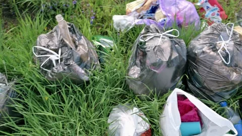 A package of plastic garbage lies in the forest on a forest road, pollution of Stock-Footage 171995214