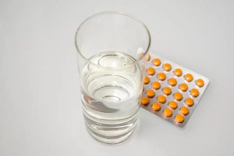 A package of red and blue tablets is placed on a white background 写真素材