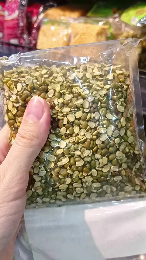 Package of split green mung beans held in hand at grocery store Stock Footage 338031822