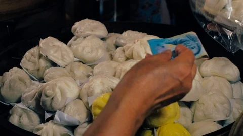 A package of steamed Dim Sum is sold at a market stand in exchange of Thai Money Stock Footage 124569936