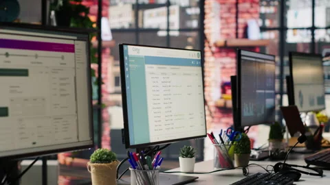 Package tracking software and spreadsheets displayed on PC screens in office Stock Footage 305393560