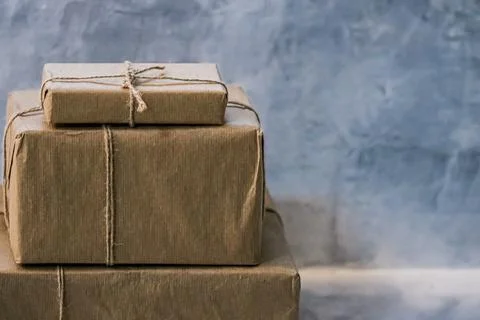 Packaged boxes for postal delivery service, parcels wrapped in brown paper and Fotos Stock