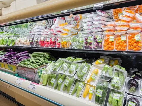 Packaged fresh vegetables displayed on refrigerated shelves in a grocery st.. Fotos de archivo