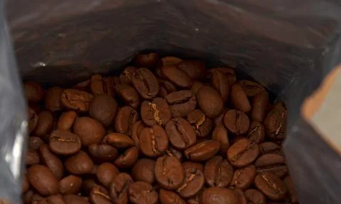 Packaged freshly roasted coffee beans. Coffee in the bag. Grains. Stock Photos