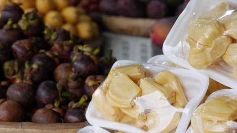 Packaged jackfruit pieces placed in a plastic container with assorted tropical 库存影片 333981995