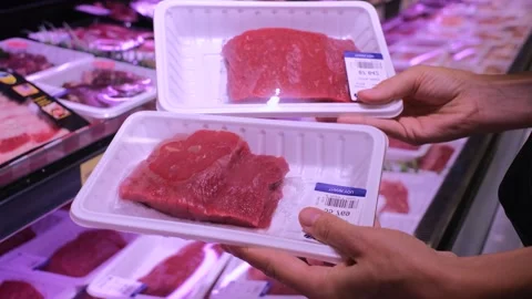 Packaged pieces of raw fresh beef laid out in supermarket refrigerator. Human Stock Footage 258106216