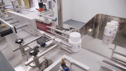 Packaged plastic containers with drugs move on conveyor belt in the workshop of Stock Footage 200857059