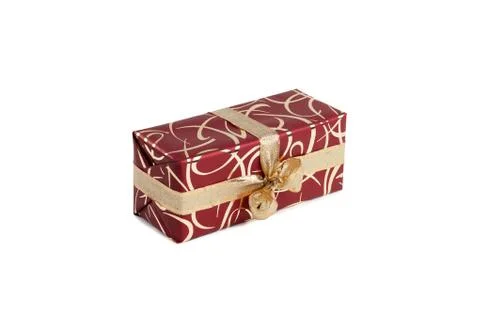 Packaged rectangular gift in burgundy packaging with gold bow and gold pattern Stock Photos