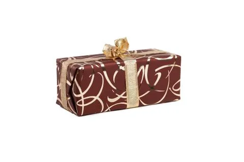 Packaged rectangular gift in dark brown packaging with gold bow and gold pattern Stock Photos