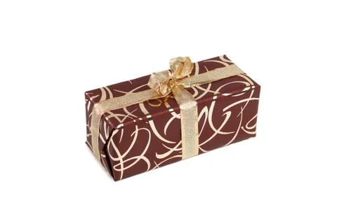Packaged rectangular gift in dark brown packaging with gold bow and gold pattern Stock Photos