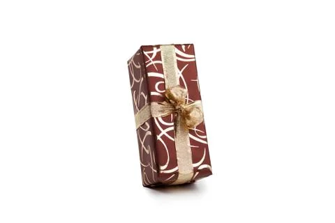 Packaged rectangular gift in dark brown packaging with gold bow and gold pattern Stock Photos