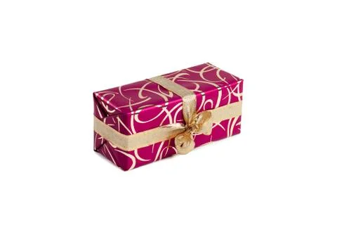 Packaged rectangular gift in dark pink packaging with gold bow and gold pattern Foto stock