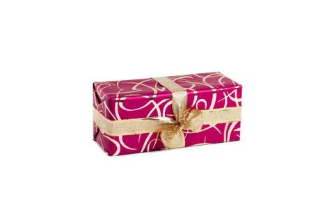 Packaged rectangular gift in dark pink packaging with gold bow and gold pattern Foto stock