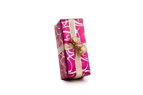 Packaged rectangular gift in dark pink packaging with gold bow and gold pattern Foto stock