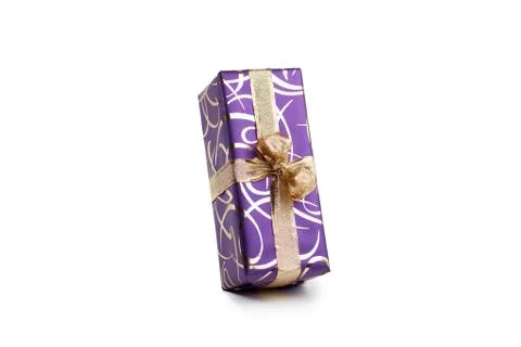 Packaged rectangular gift in purple packaging with gold bow and gold pattern on Stock Photos